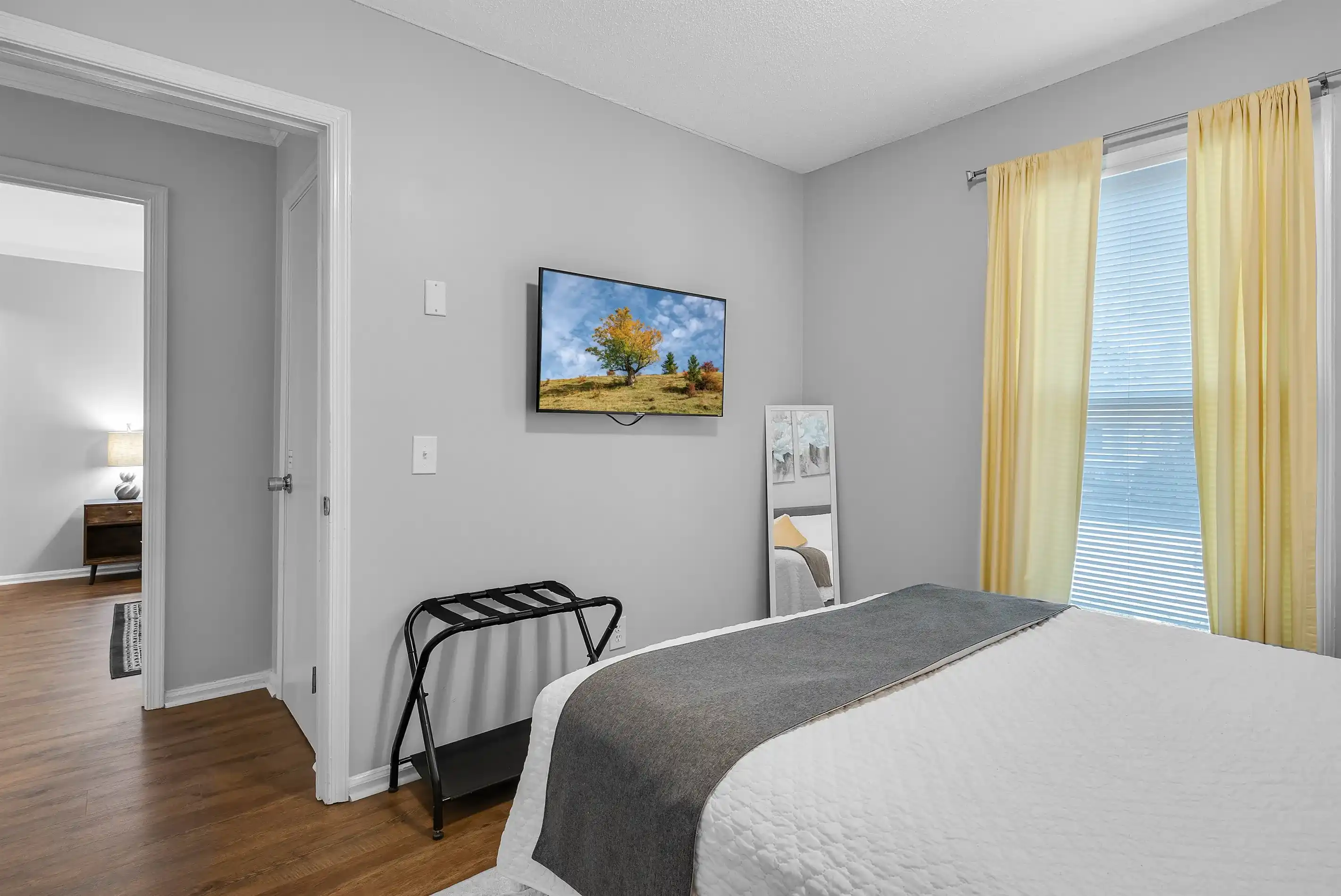 Each bedroom has a wall-mounted smart TV, luggage rack, closet for your belongings, and 2 nightstands with lamps.