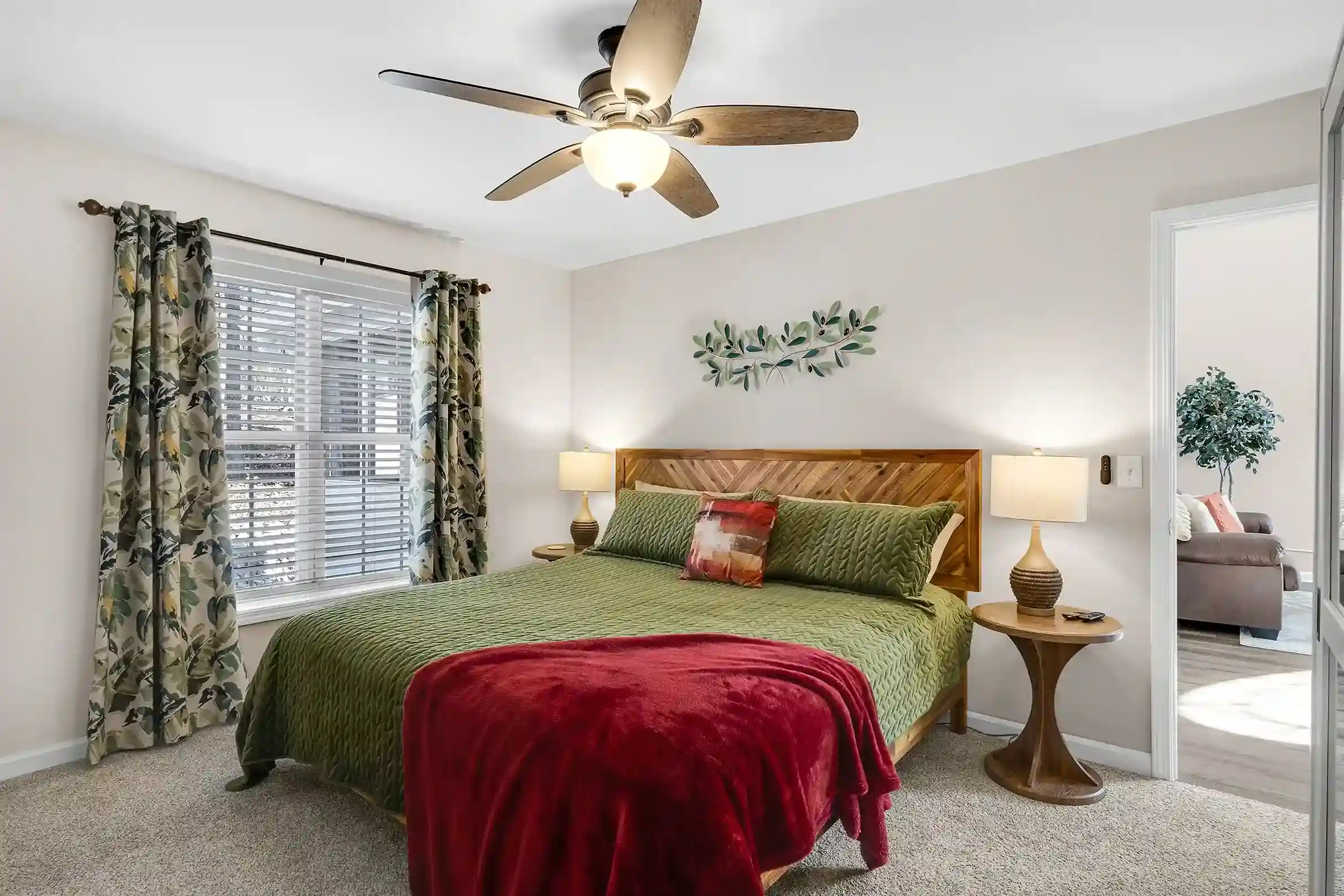 A cozy master bedroom featuring a plush king-sized bed with an adjustable base, surrounded by black-out curtains for a restful night's sleep.