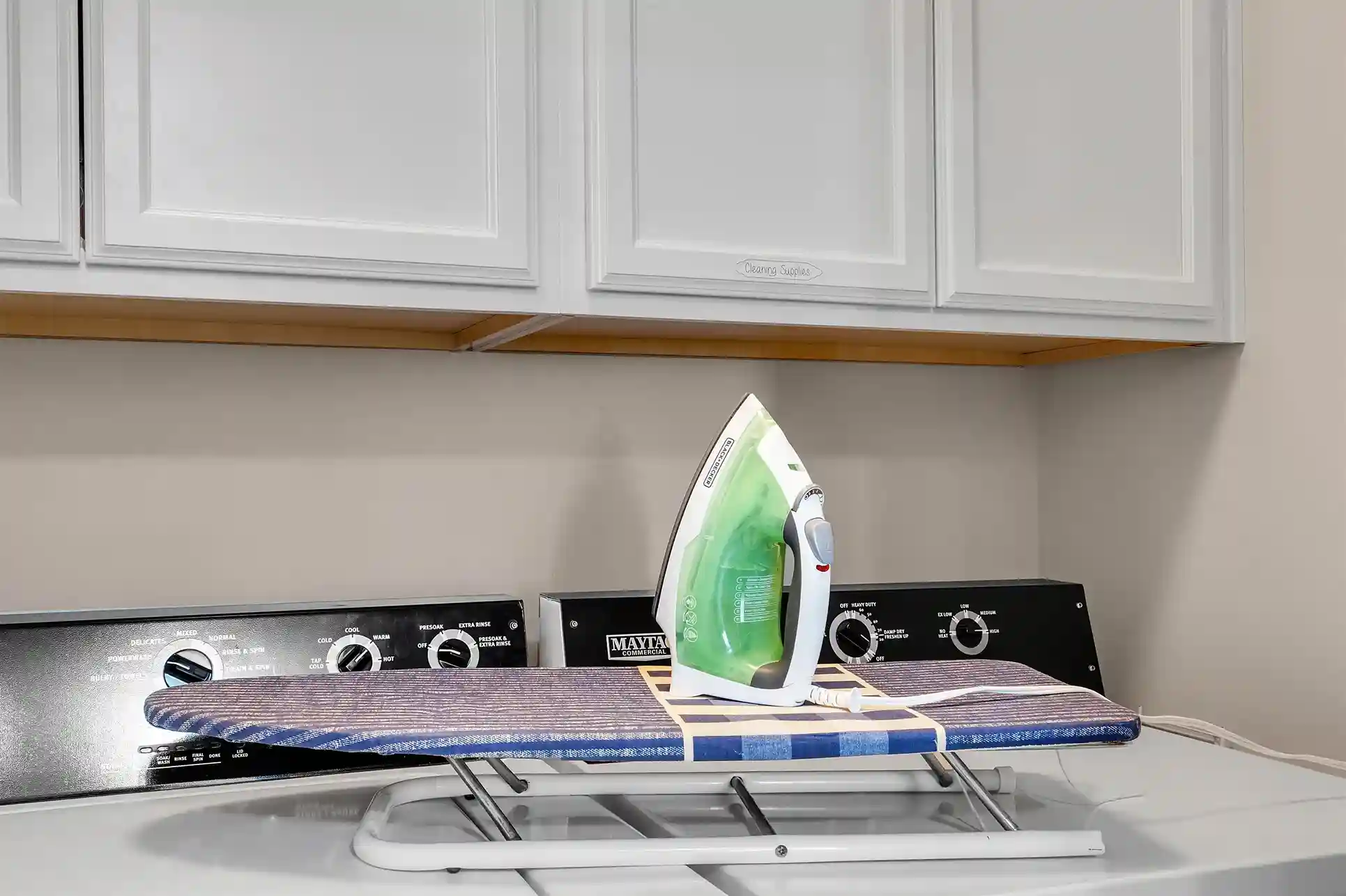 A convenient laundry room equipped with a washer, dryer, and an iron with ironing board for guest use.